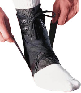 Active male athlete with a supportive ankle brace during intense sports training