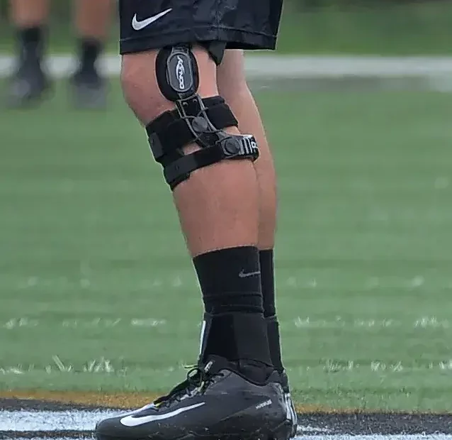 Football player confidently tackles with a sturdy knee brace for added support