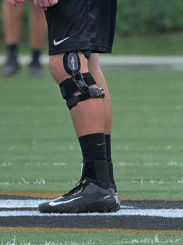 Football player confidently tackles with a sturdy knee brace for added support